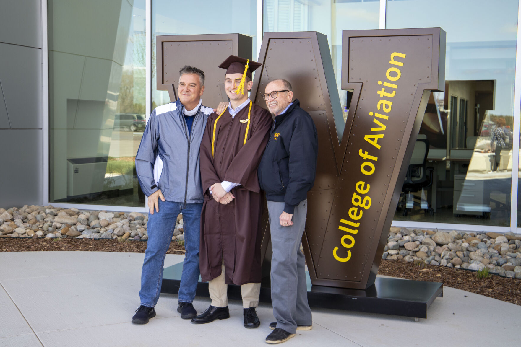 A WMU graduate and his father pose for a picture with College of Aviation Dean Captain Dave Powell.